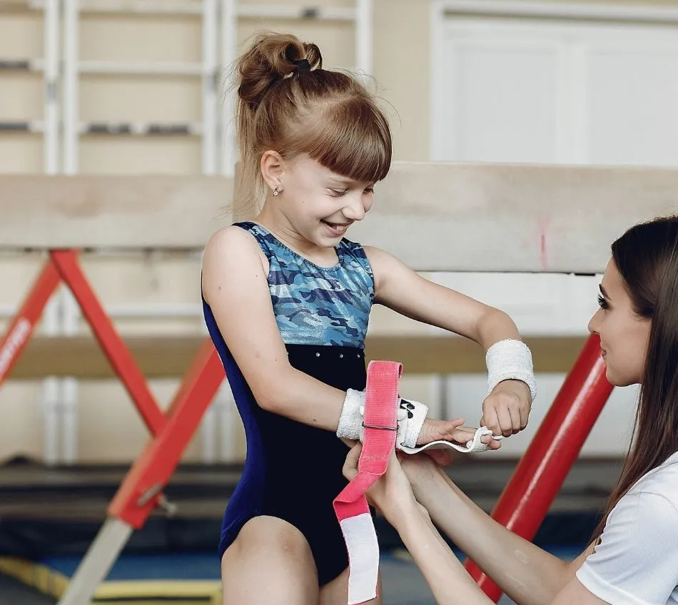 Gymnast putting on uneven bars grips. Visit Our Store website page image